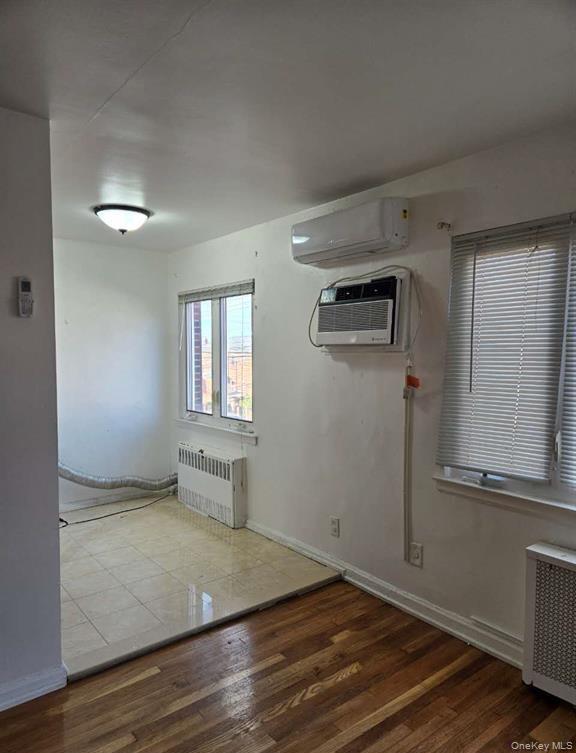 132-20 60th Avenue Queens, NY 11355 - Photo 3 of 8 an empty room with wooden floor cabinet and windows