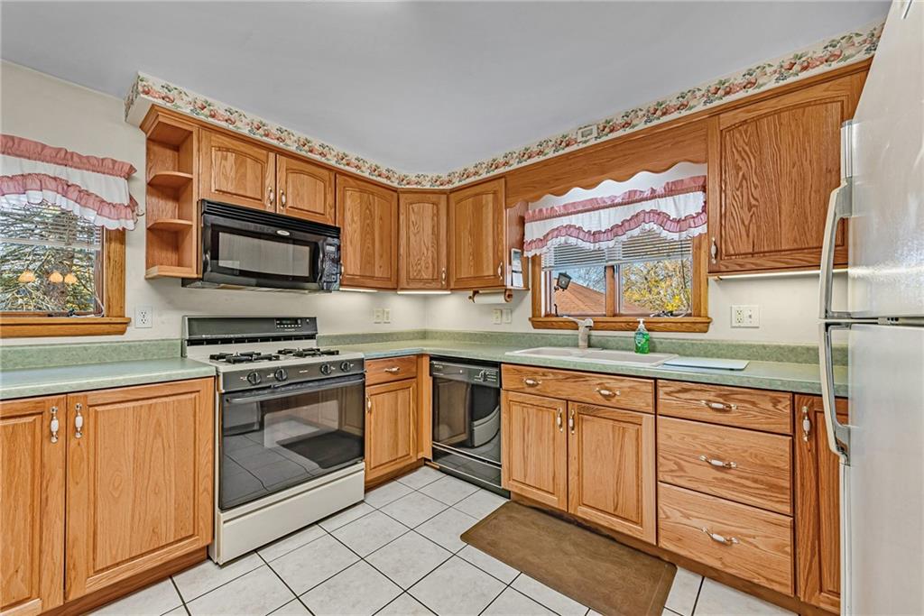 4931 North Rt, Unit 982 Latrobe, PA 15650 - Photo 7 of 22 a kitchen with stainless steel appliances granite countertop a stove a sink and a microwave
