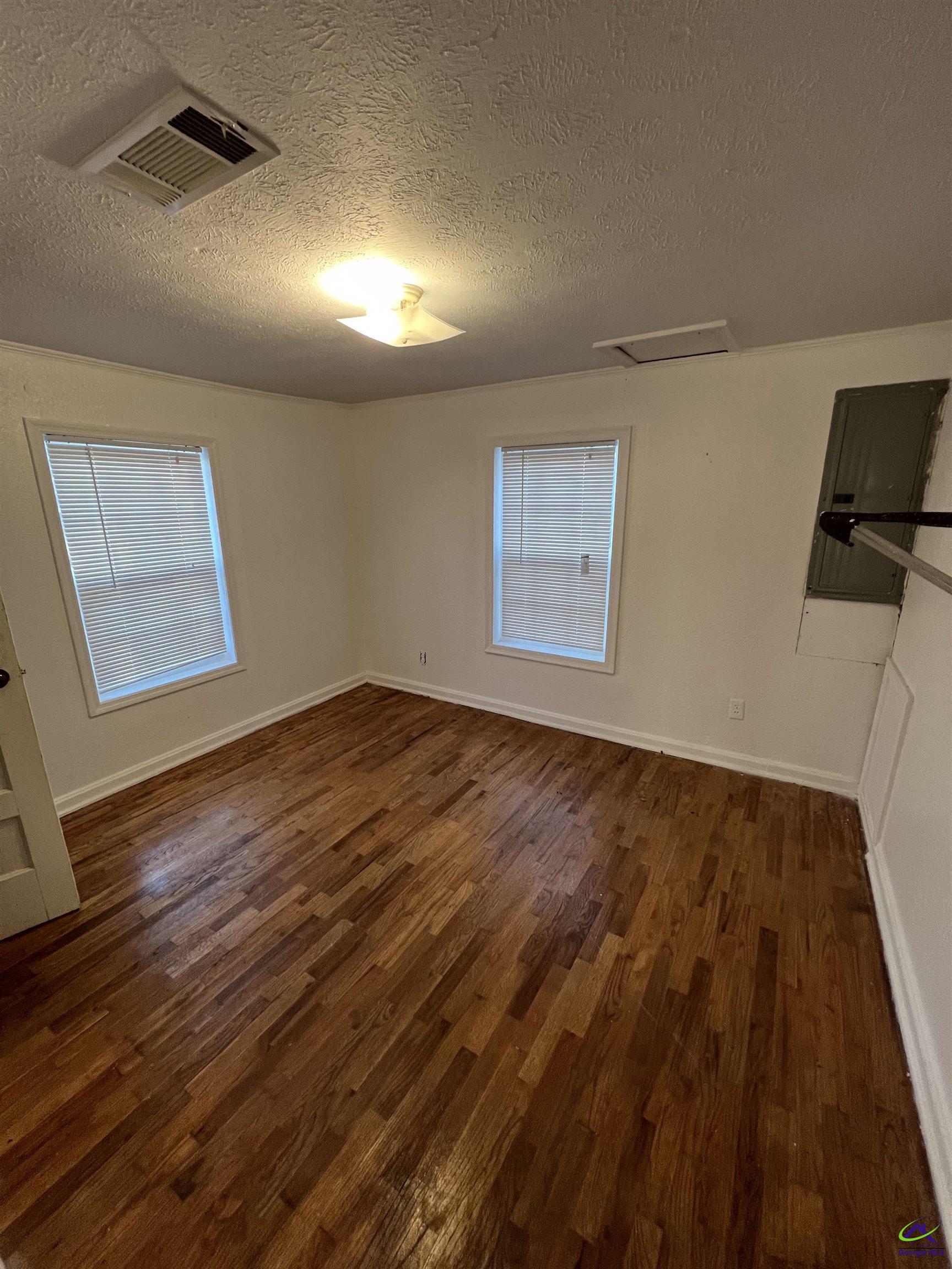 3281 State Rte 126 Dublin, GA 31021 - Photo 16 of 22 a view of empty room with wooden floor and fan