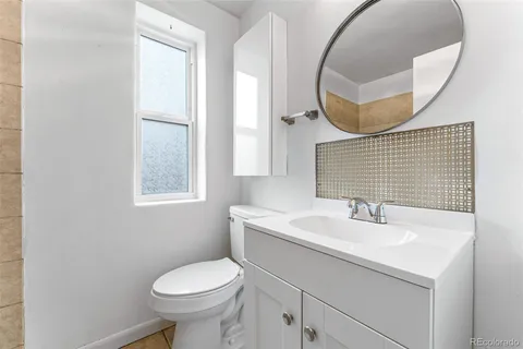 a bathroom with a sink a toilet and a mirror