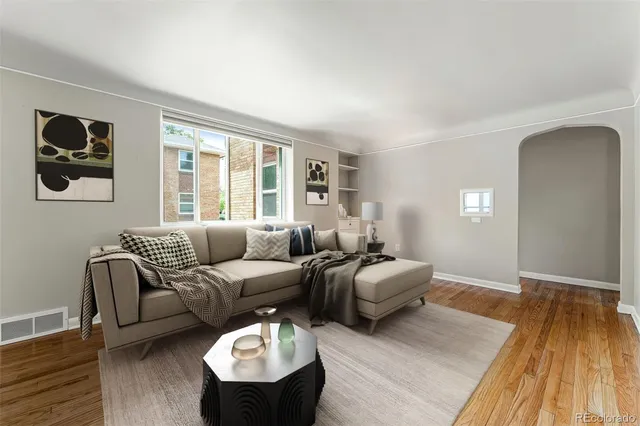 a living room with furniture and a wooden floor