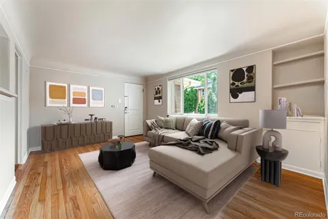 a living room with furniture a window and a wooden floor