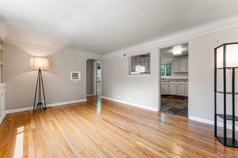 a view of empty room with wooden floor and window