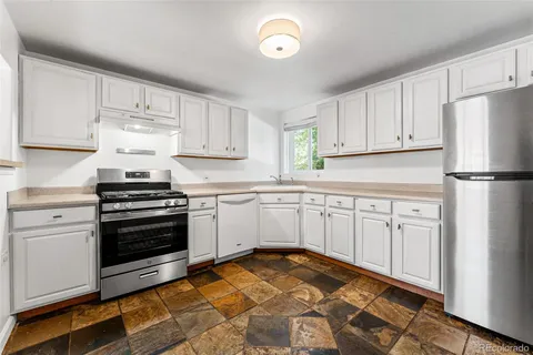 a kitchen with white cabinets and white appliances