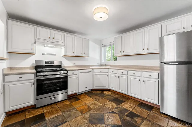 a kitchen with white cabinets and white appliances