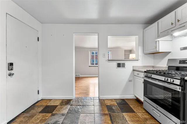 a kitchen with granite countertop a stove a sink and a refrigerator