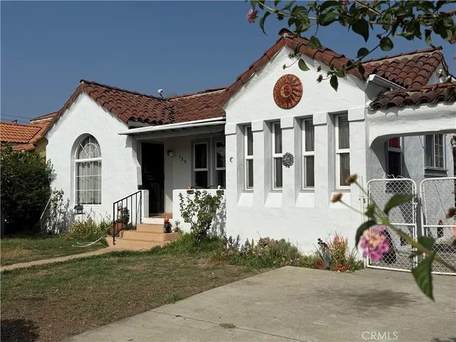 a view of a white house with large windows and a table