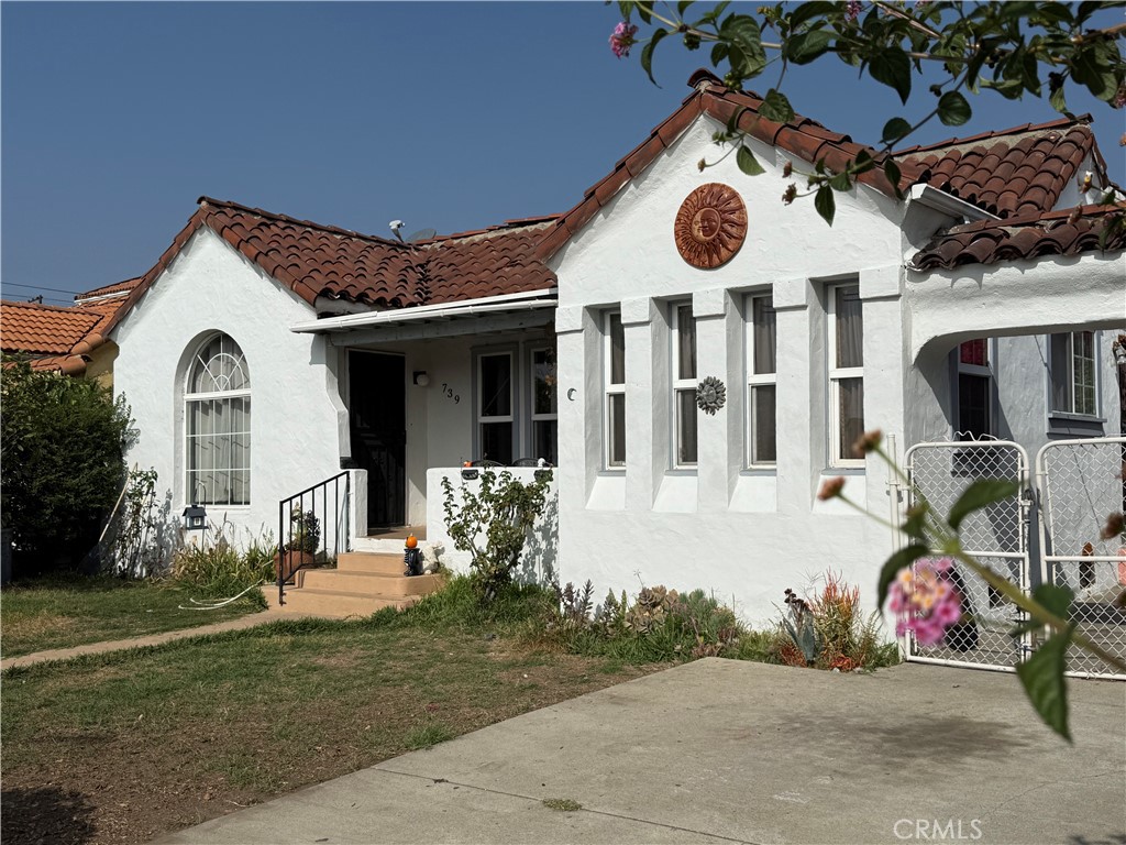 a view of a white house with large windows and a table
