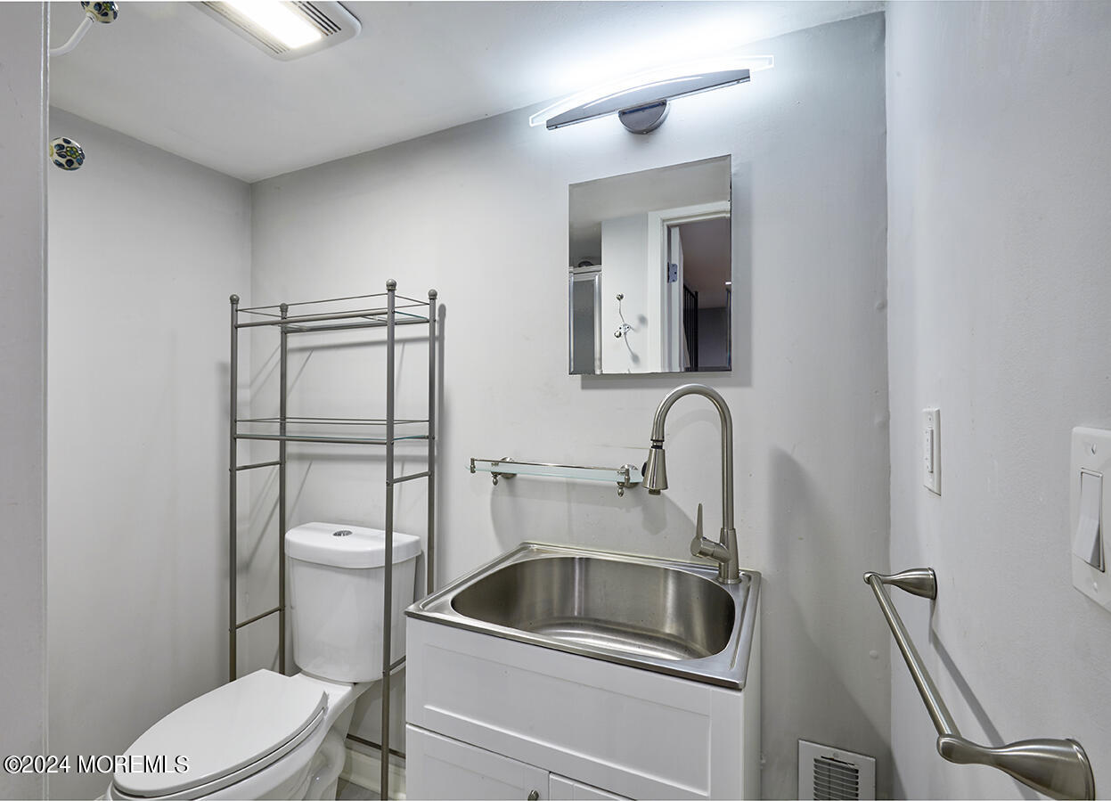 321 Spring Street, Unit 1 Red Bank, NJ 07701 - Photo 18 of 20 a bathroom with a toilet sink and mirror