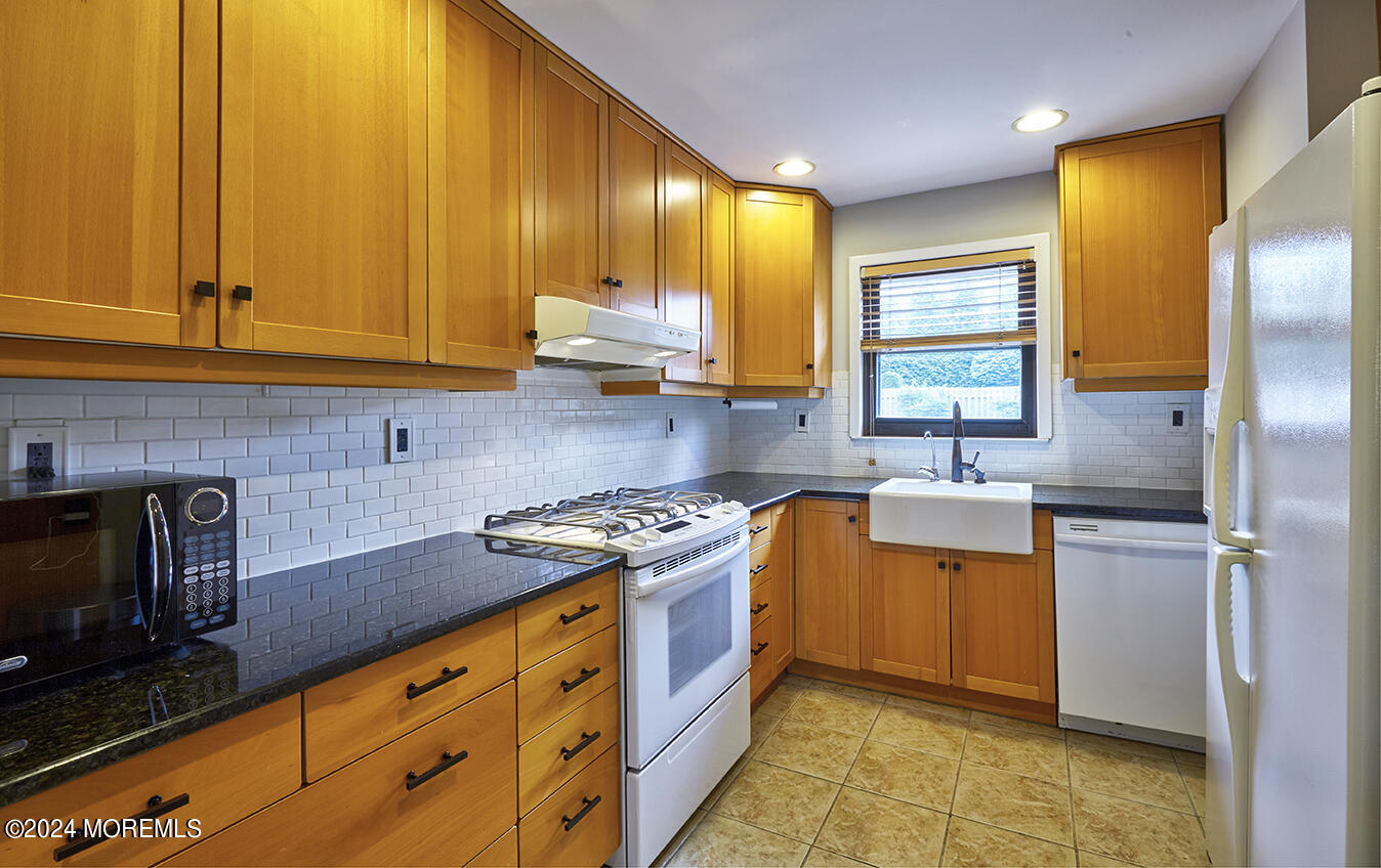 321 Spring Street, Unit 1 Red Bank, NJ 07701 - Photo 3 of 20 a kitchen with stainless steel appliances granite countertop a sink a stove and a refrigerator
