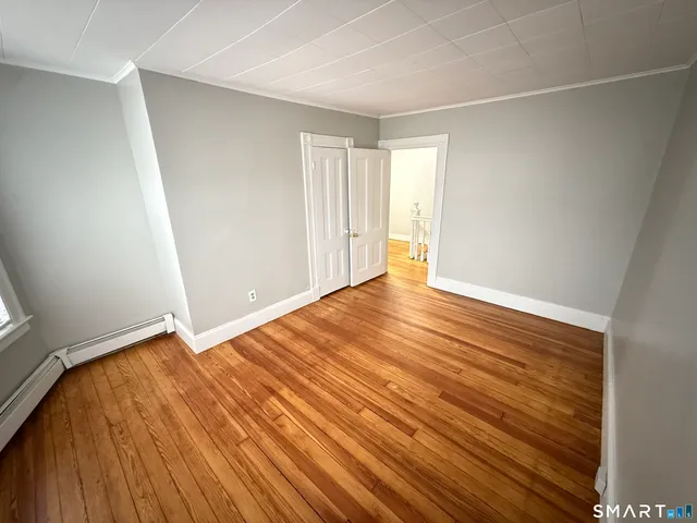 a view of an empty room with wooden floor