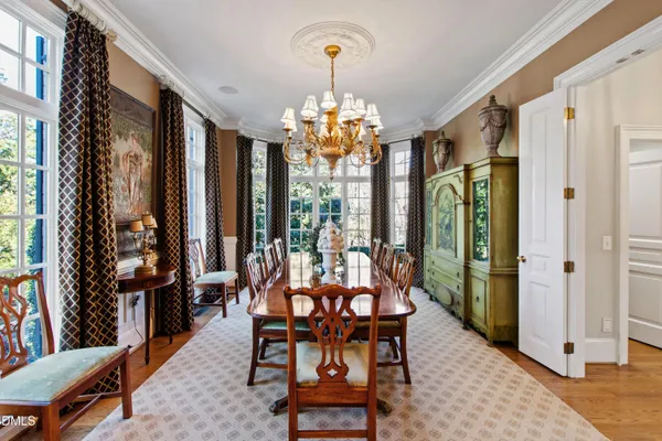 a dining room with furniture a chandelier and wooden floor