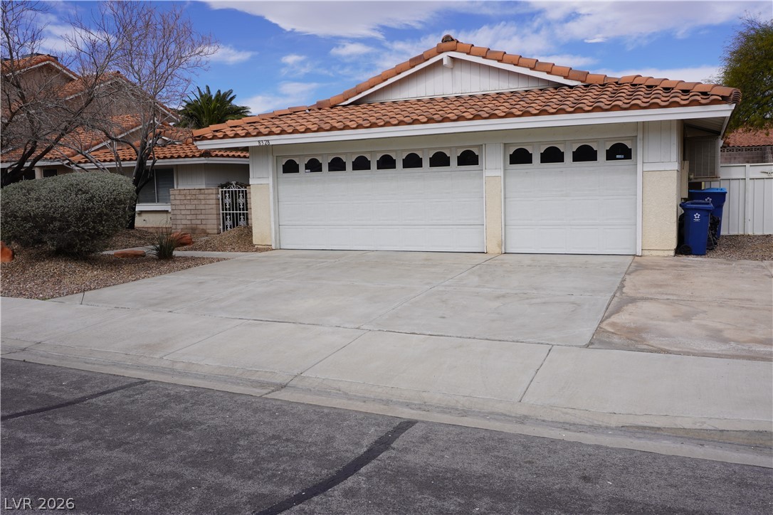 8328 Del Rey Avenue Las Vegas, NV 89117 - Photo 2 of 38 A well-maintained concrete driveway leads to a home featuring a double garage and traditional tile roof.