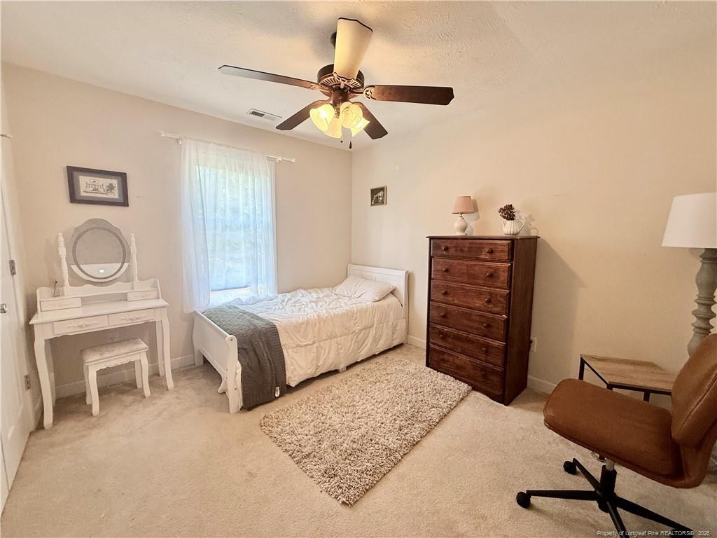 234 Pender Road Spring Lake, NC 28390 - Photo 31 of 39 a bedroom with a bed a chair and a chandelier