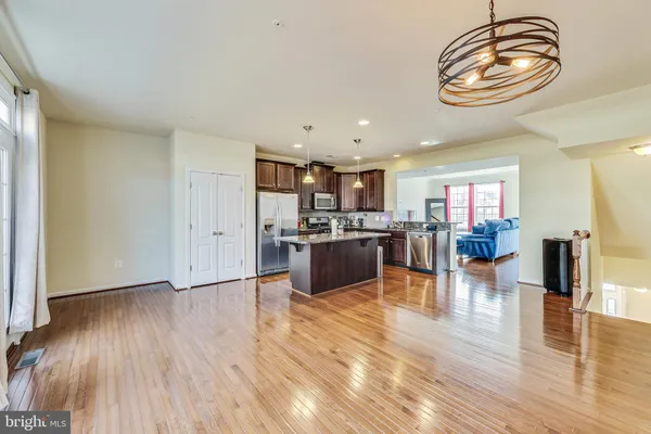 a kitchen with a wooden floor and chandelier