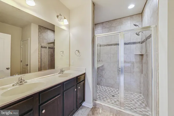 a bathroom with a double vanity sink mirror and shower