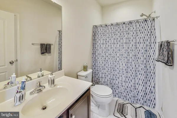 a bathroom with a sink a toilet and shower curtain
