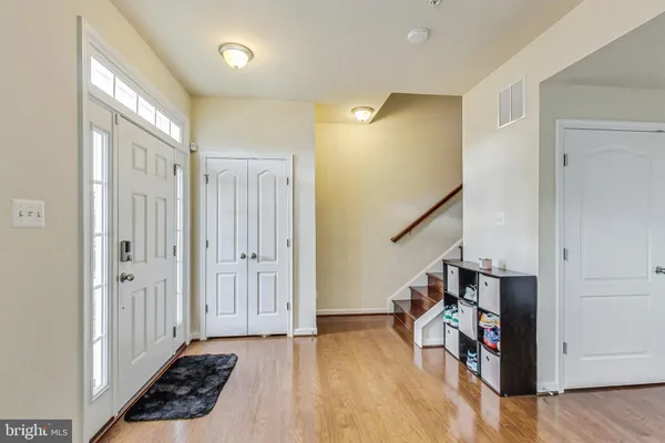 a view of a hallway with wooden floor and staircase