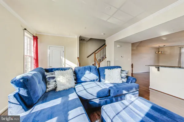 a living room with furniture and a refrigerator