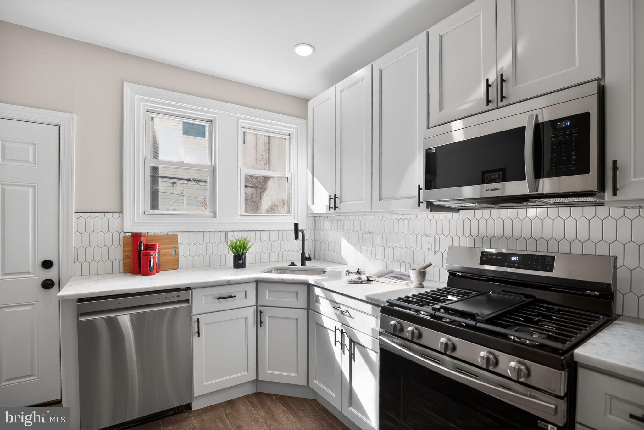 2014 Moore Street Philadelphia, PA 19145 - Photo 12 of 26 a kitchen with stainless steel appliances a stove a microwave sink and cabinets