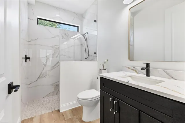 a bathroom with a granite countertop sink toilet and shower