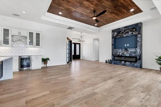 a view of an empty room with wooden floor and a fireplace