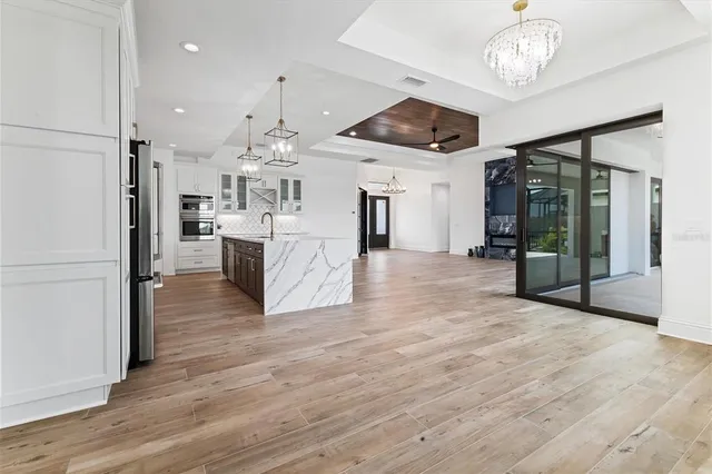 a large kitchen with cabinets wooden floor and stainless steel appliances