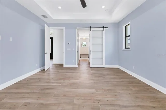 a view of an empty room with wooden floor and closet