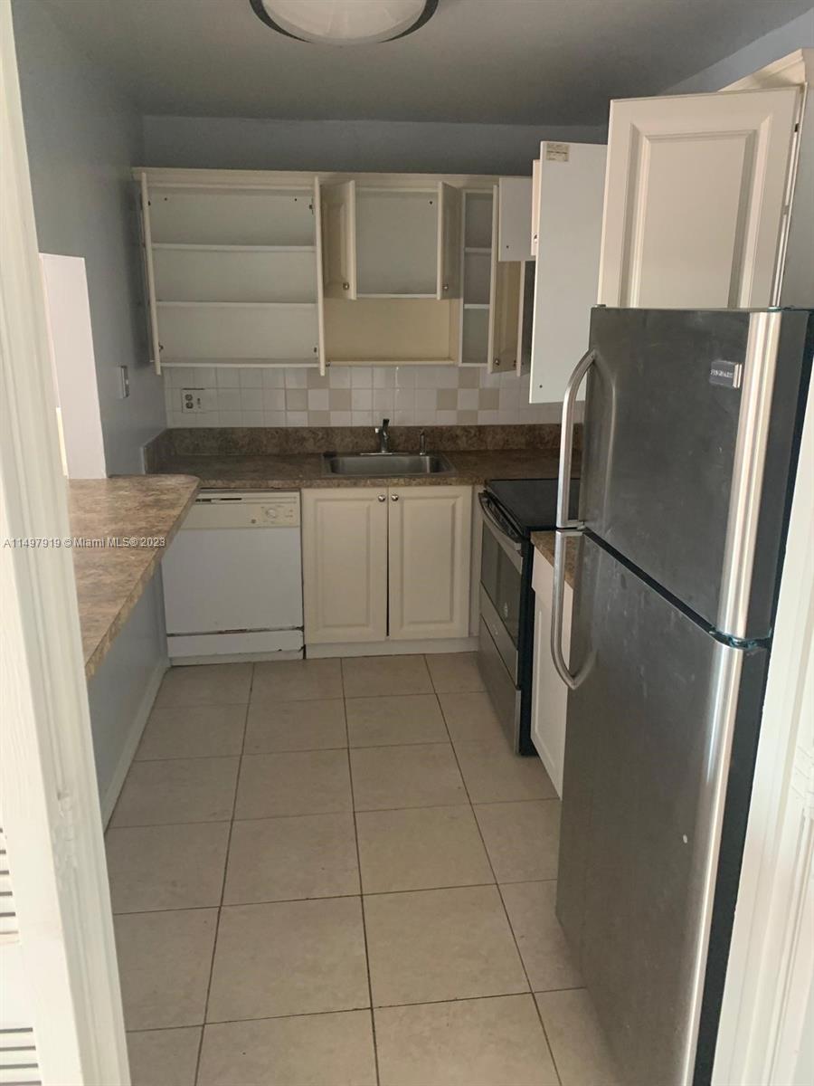 4174 Inverrary Drive, Unit 906 Lauderhill, FL 33319 - Photo 5 of 9 a kitchen with a refrigerator sink and cabinets