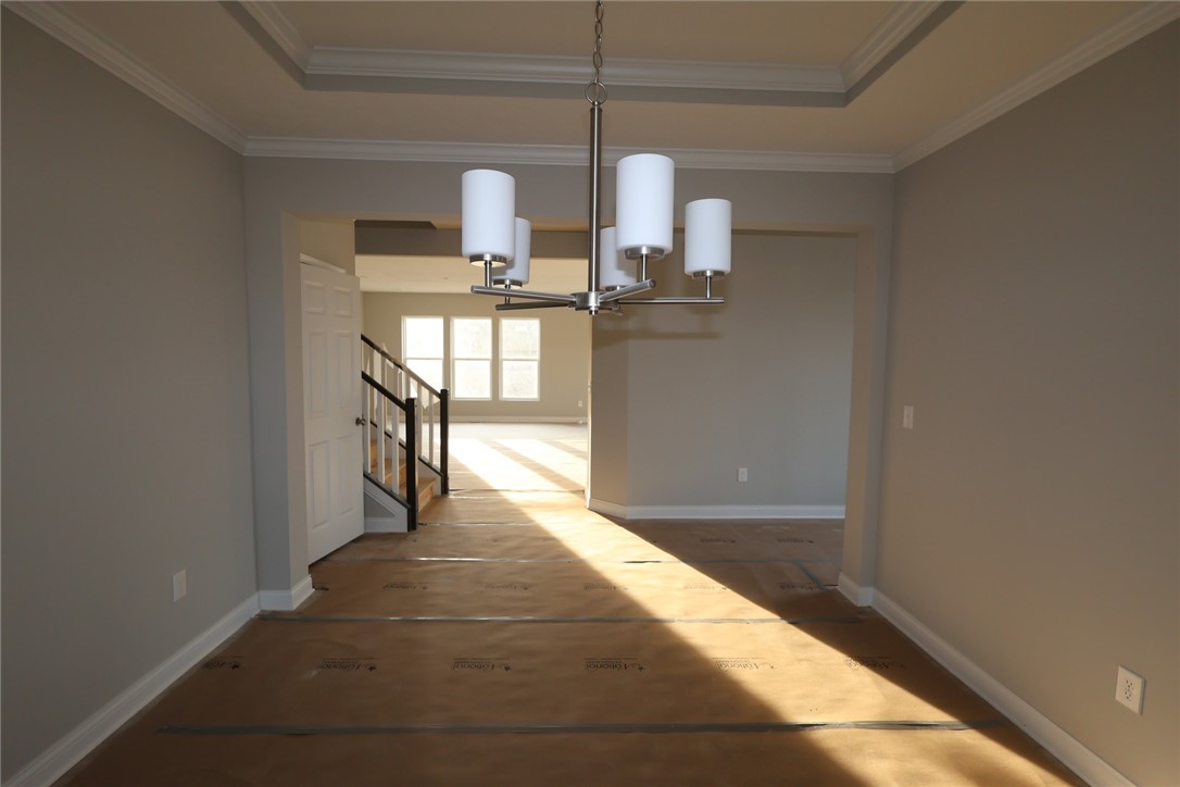 230 Tilly Court, Unit 4 Springboro, OH 45066 - Photo 8 of 20 This bright interior features crown molding and a stylish chandelier, offering a welcoming atmosphere.