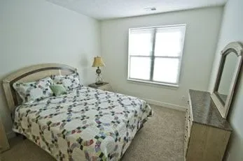 a bed sitting in a bedroom next to a window