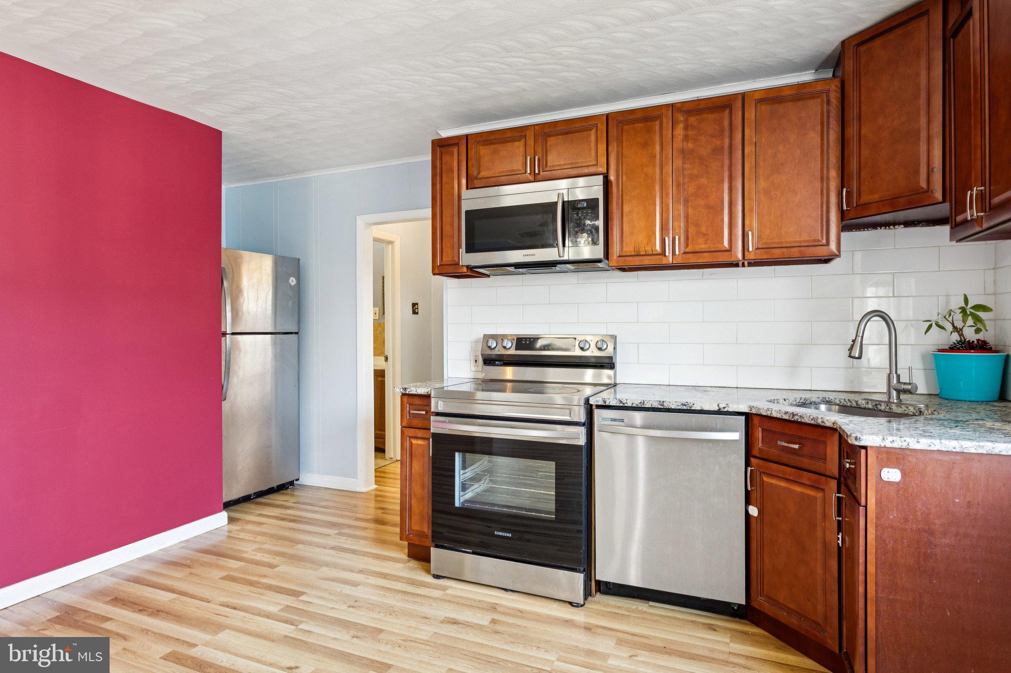 2614 Old Welsh Road Willow Grove, PA 19090 - Photo 33 of 47 a kitchen with stainless steel appliances granite countertop a stove a sink dishwasher and a refrigerator with wooden cabinets