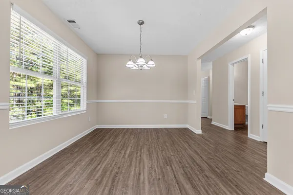 a view of a livingroom with wooden floor and a window