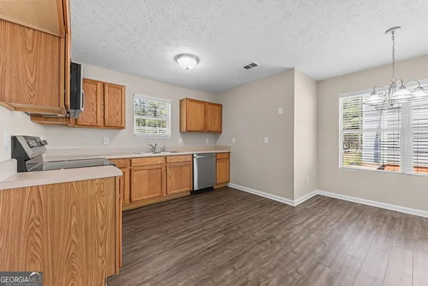 a kitchen with a sink cabinets and wooden floor