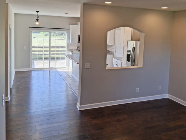 a kitchen with stainless steel appliances granite countertop a refrigerator a stove top oven and a dishwasher with wooden floor