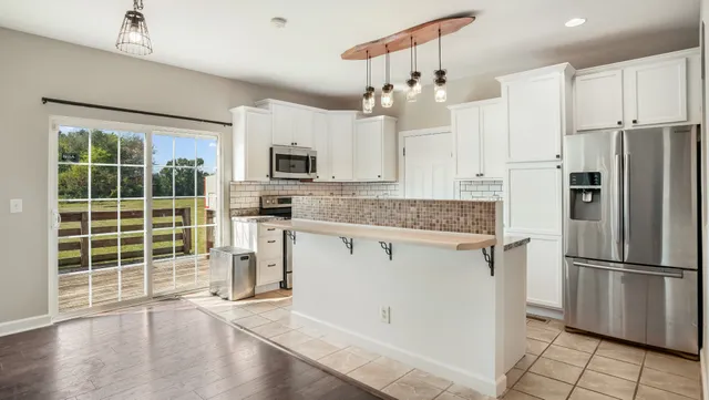 a kitchen with stainless steel appliances granite countertop a sink refrigerator and cabinets