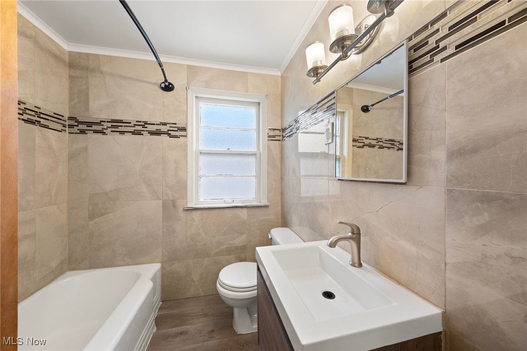 13517 Cedar Road Cleveland, OH 44118 - Photo 8 of 30 Full bathroom with hardwood / wood-style floors, crown molding, toilet, tile walls, and tiled shower / bath combo