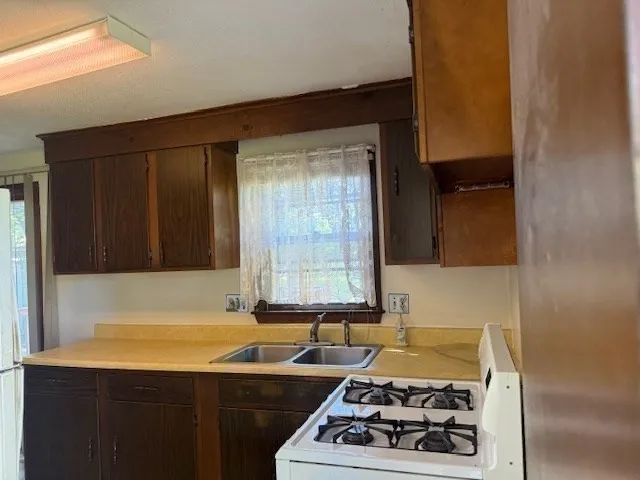 a kitchen with a sink and a stove next to a window
