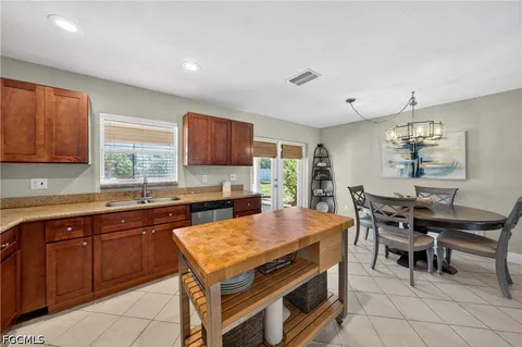 a kitchen with a stove a sink dishwasher and white cabinets with wooden floor