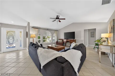 a living room with furniture a flat screen tv and a window