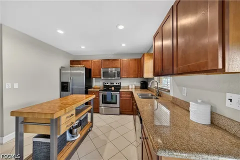 a kitchen with stainless steel appliances granite countertop a refrigerator sink and stove