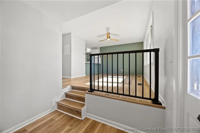 a view of a hallway with wooden floor and a window