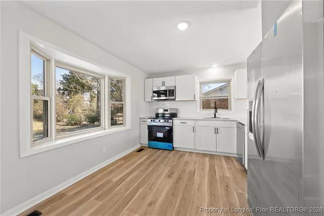 a kitchen with stainless steel appliances a refrigerator sink and cabinets