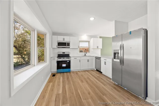 a kitchen with stainless steel appliances a refrigerator sink and microwave