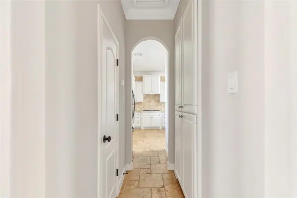 a view of a hallway with wooden floor and a bathroom