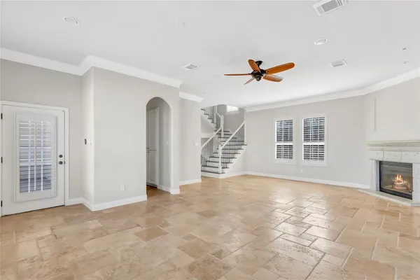 an empty room with windows and a ceiling fan