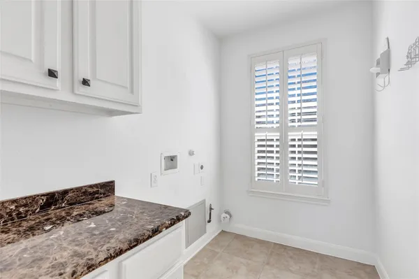 a kitchen with white cabinets and a window