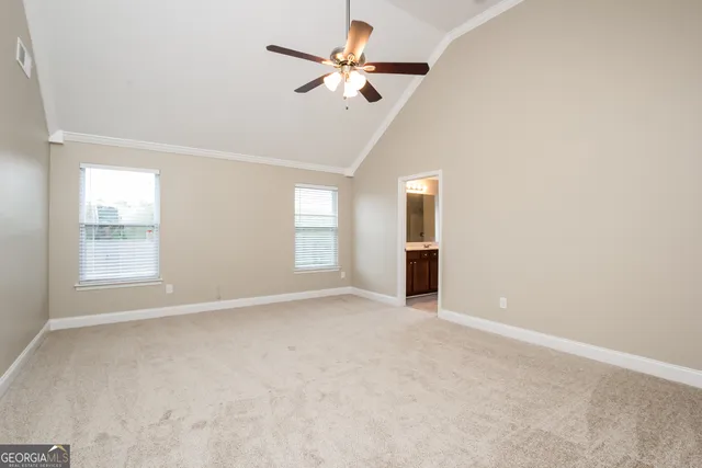 an empty room with windows and fan