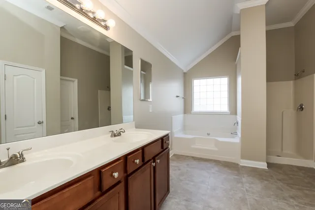 a bathroom with a tub a sink and mirror