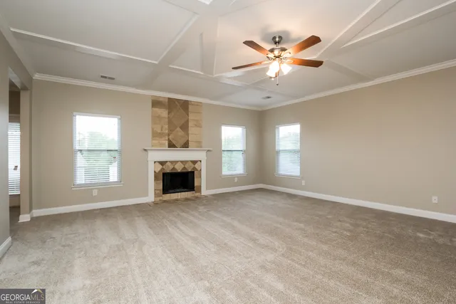 a view of an empty room with window and fireplace